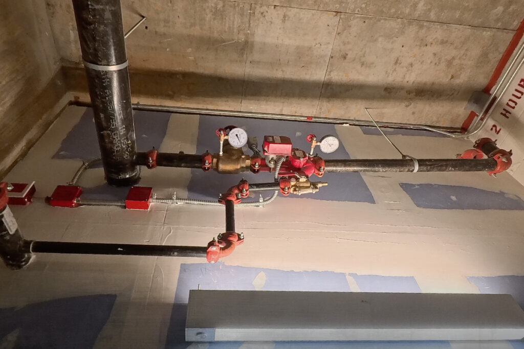 Fire sprinkler valves and piping in a commercial building, comparing a wet vs dry sprinkler system