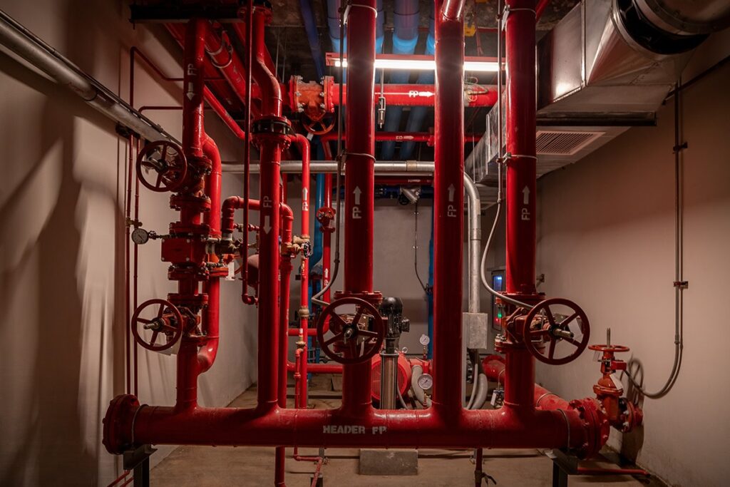 Red fire pump room piping with control valves in a commercial building