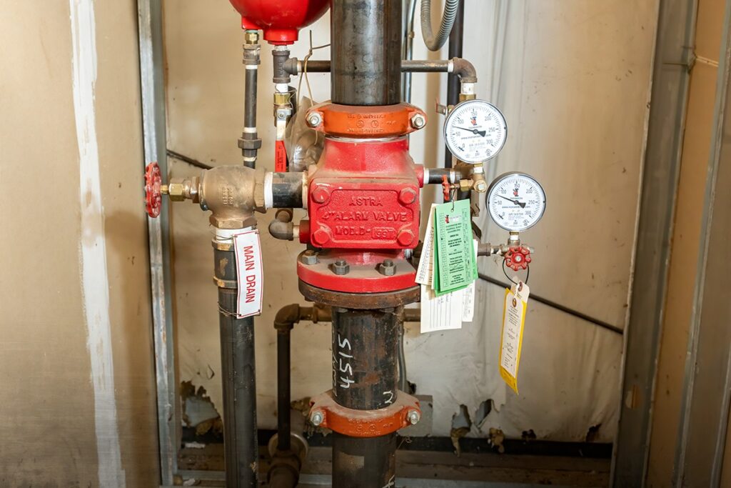 Dry pipe sprinkler valve riser with pressure gauges and inspection tags